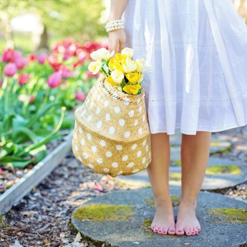 woman holding brown basket with yellow flowers