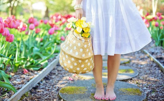 woman holding brown basket with yellow flowers
